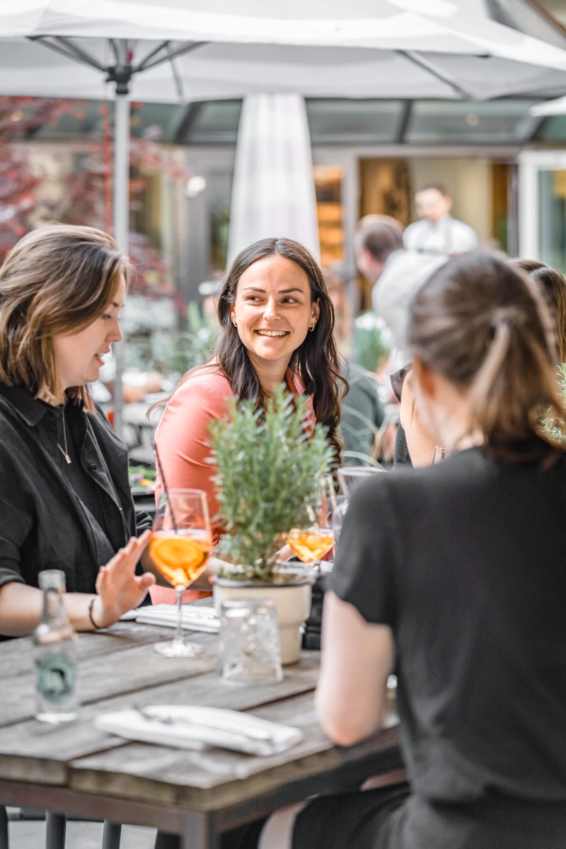 G&auml;ste genie&szlig;en Drinks im Au&szlig;enbereich des Hotels.