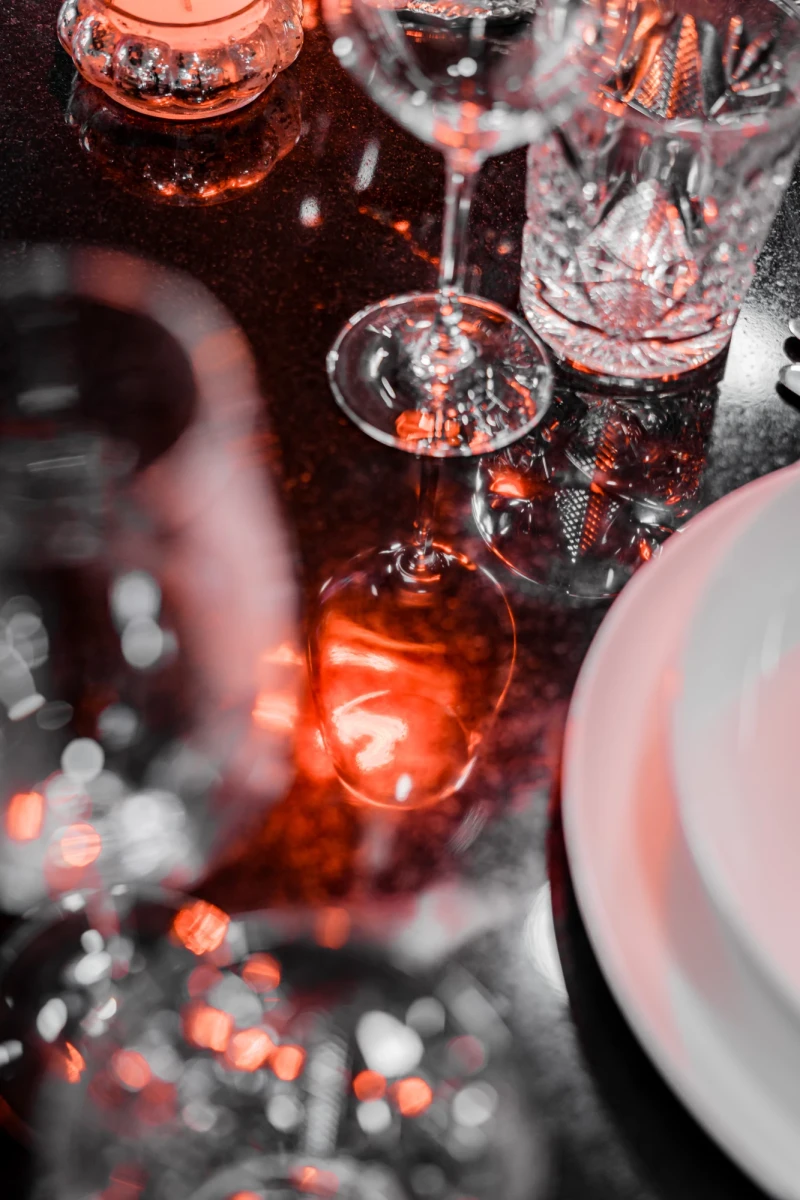 Elegant gedeckter Tisch mit Gläsern und Kerzenlicht in Eventküche.