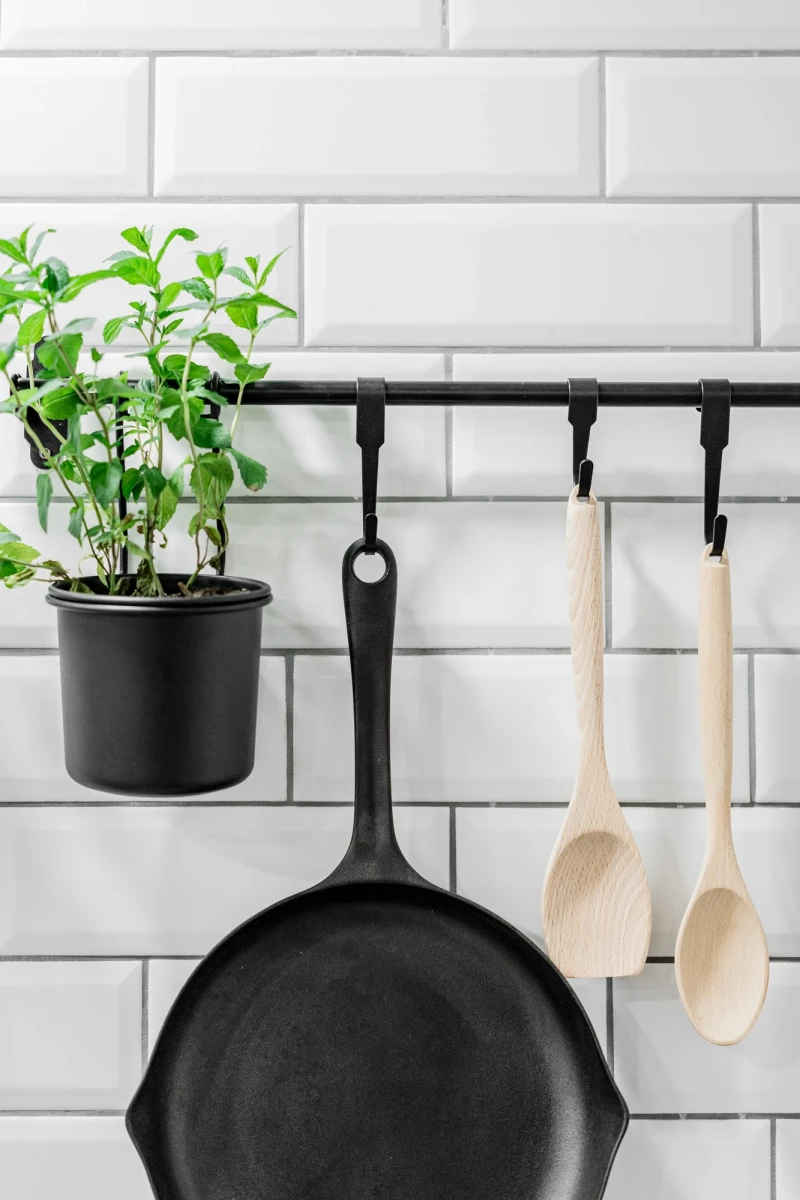 Küchenutensilien und frische Kräuter in modernem, minimalistischen Design.
