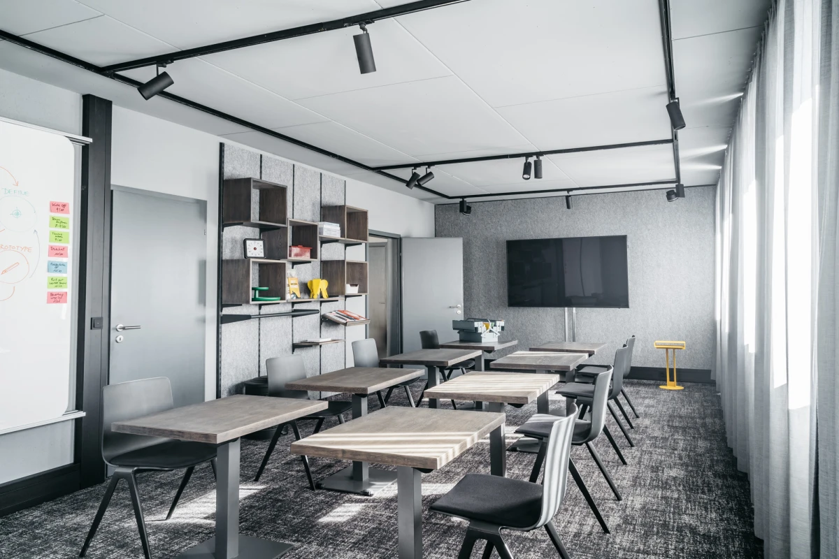 Moderner Konferenzraum im Schwarzen Adler mit h&ouml;henverstellbaren Tischen und St&uuml;hlen.