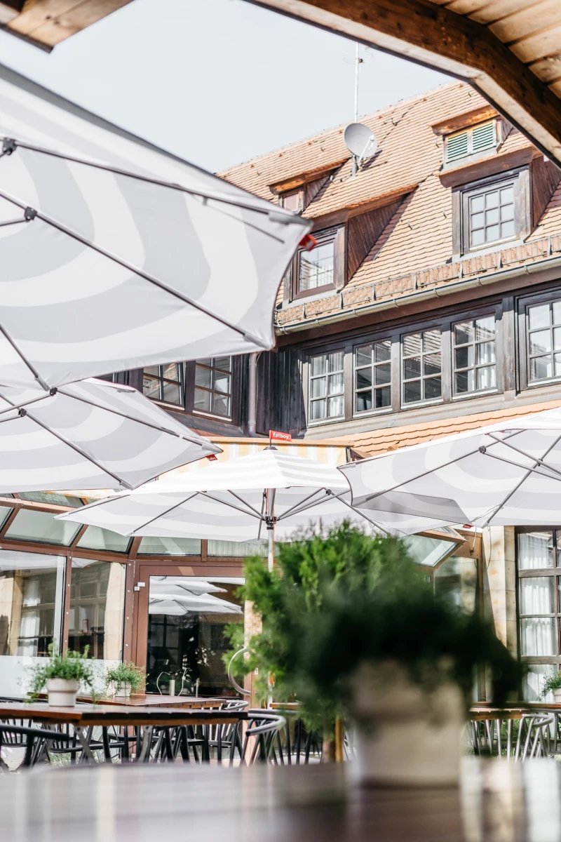 Hotel Riesengebirge Außenbereich mit Sonnenschirmen und gemütlicher Terrasse.