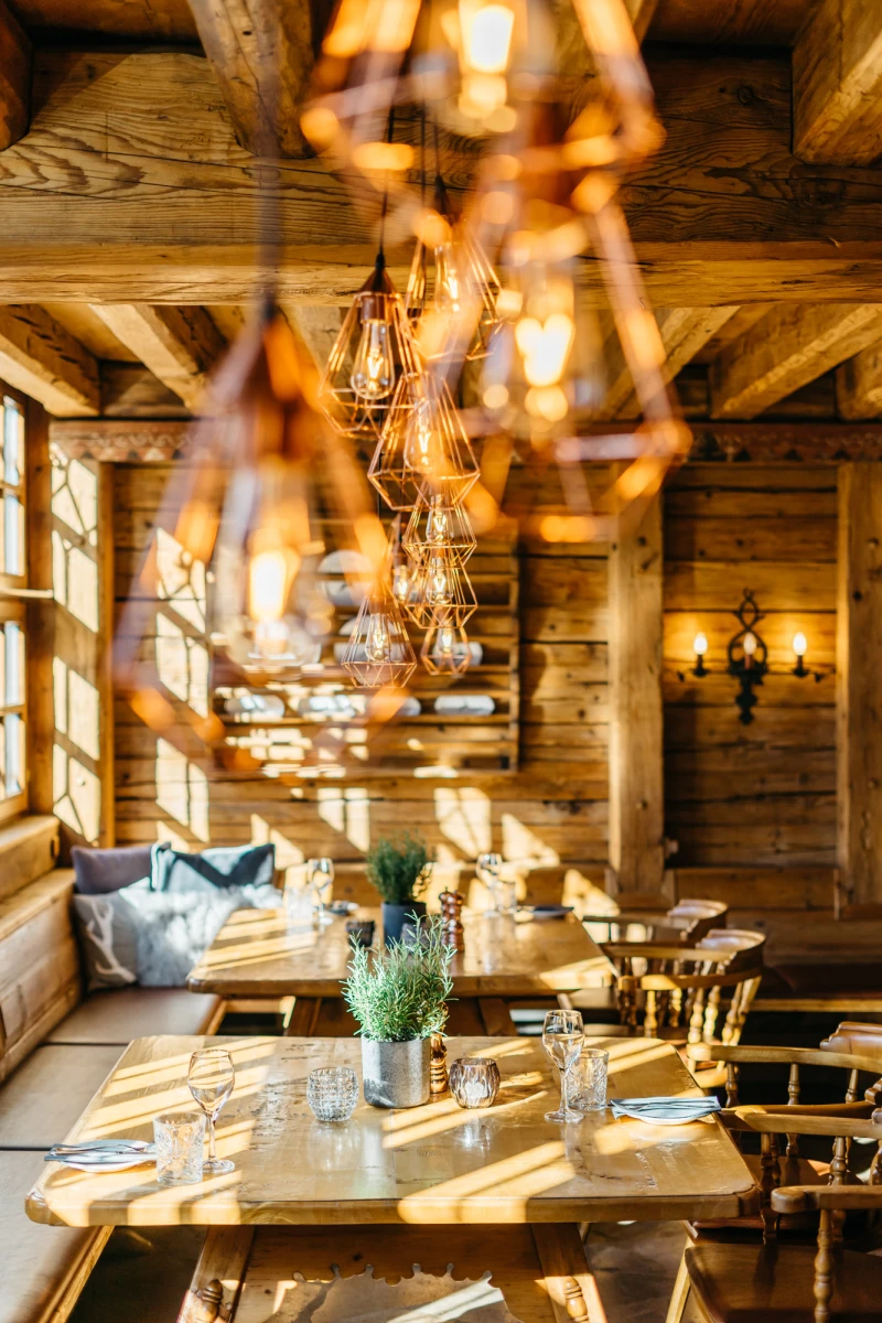 Gemütliche Riesengebirgsstube im Hotel Riesengebirge mit Holzmöbeln und moderner Beleuchtung.