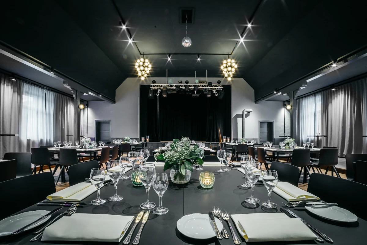 Eleganter Festsaal im Schwarzen Adler, festlich gedeckte Tische, Kronleuchter, B&uuml;hne.